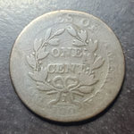 Old coin with text and design on a dark background