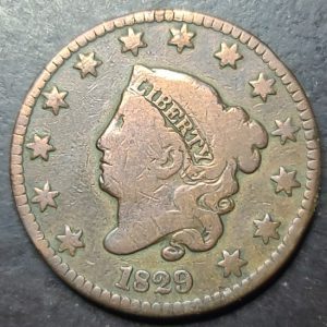 Vintage coin with a profile of a person and the year 1829 on a dark background