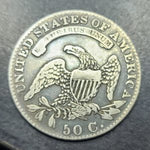 Silver coin with an eagle design and 'United States of America' text on a dark background