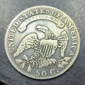 Silver coin with an eagle design and 'United States of America' text on a dark background