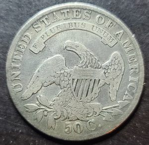 Silver U.S. coin with an eagle emblem on a dark background