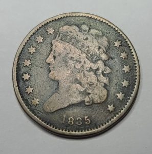 Vintage half cent coin with a head design on a gray background