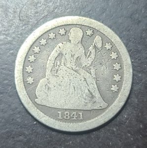 Vintage silver coin with a portrait and '1841' on a dark background