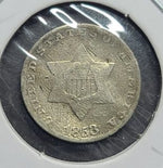 Silver coin with star design on a reflective surface