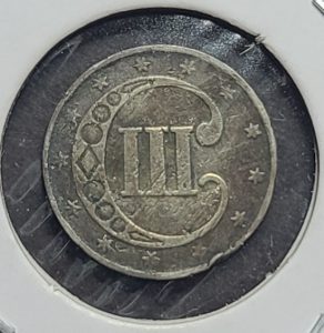 Vintage silver coin with star patterns on a black background