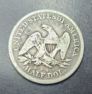 Silver half dollar coin with an eagle design on a dark background