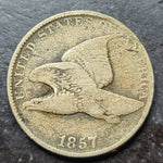 Vintage United States coin with eagle design and '1857' on a dark surface