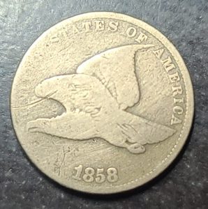 coin with a eagle design and '1858' on a dark background