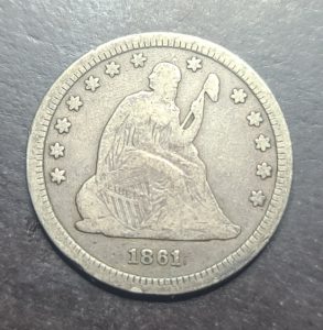 Silver coin with a portrait and '1861' on a dark background
