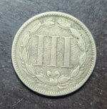 coin with a central design on a dark surface