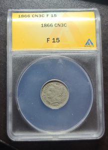 Coin in a protective case with a yellow label on a dark background
