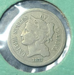 coin with a profile of a person and 'United States of America' text, on a green background.