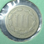 Metallic coin with emblem on a green background