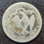 Vintage silver coin with detailed design on a dark surface