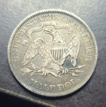 Silver half dollar coin with an eagle design on a dark background