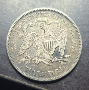 Silver half dollar coin with an eagle design on a dark background