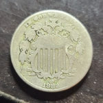 Old coin with intricate design on a dark surface