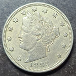 Silver coin with a profile of a woman and the year 1883 on a dark background