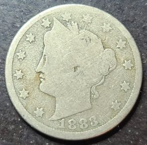 Vintage silver coin with profile of a woman and date 1883 on a dark background