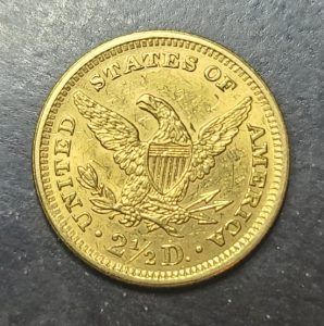 Gold coin with an eagle design on a dark surface