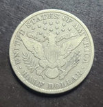 Silver half dollar coin with detailed design on a dark background