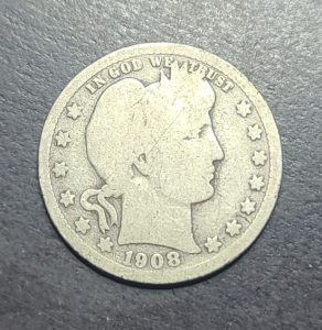 Silver coin with a profile of a woman and the year 1908 on a dark background