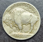 Buffalo nickel coin with a bison design on a dark background