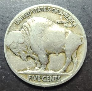 Buffalo nickel coin with a bison design on a dark background