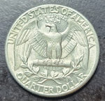 Silver quarter dollar coin with an eagle emblem on a dark background
