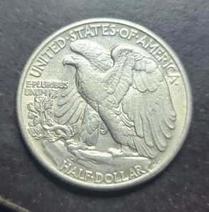 Silver half dollar coin with an eagle design on a dark background