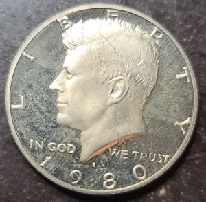 Kennedy Half Dollar coin with 'In God We Trust' inscription on a dark background