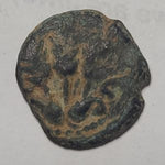 Ancient bronze coin with intricate design on a gray background