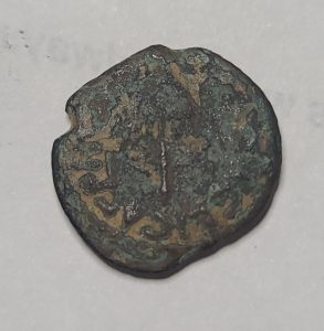 Bronze coin with engraved text on a gray background