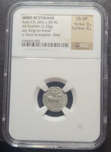 Ancient coin in a protective case with grading information