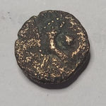 Biblical bronze coin with intricate design on a gray background