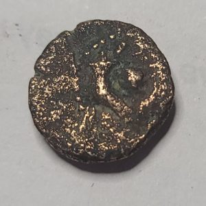 Biblical bronze coin with intricate design on a gray background