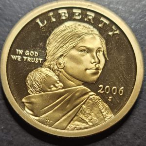 Gold-colored coin with a portrait and 'Liberty' text on a dark background