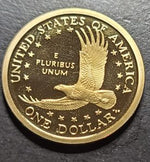 Gold United States dollar coin with an eagle and text on a dark background