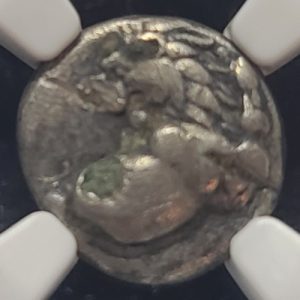 Ancient silver coin with a detailed design on a white background