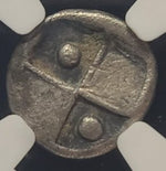 Close-up of a metallic coin with a cross design on a white background