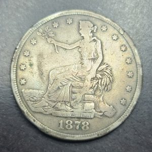 Silver coin with a portrait and '1878' on a dark background