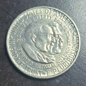 Silver U.S. coin with portraits on a dark surface